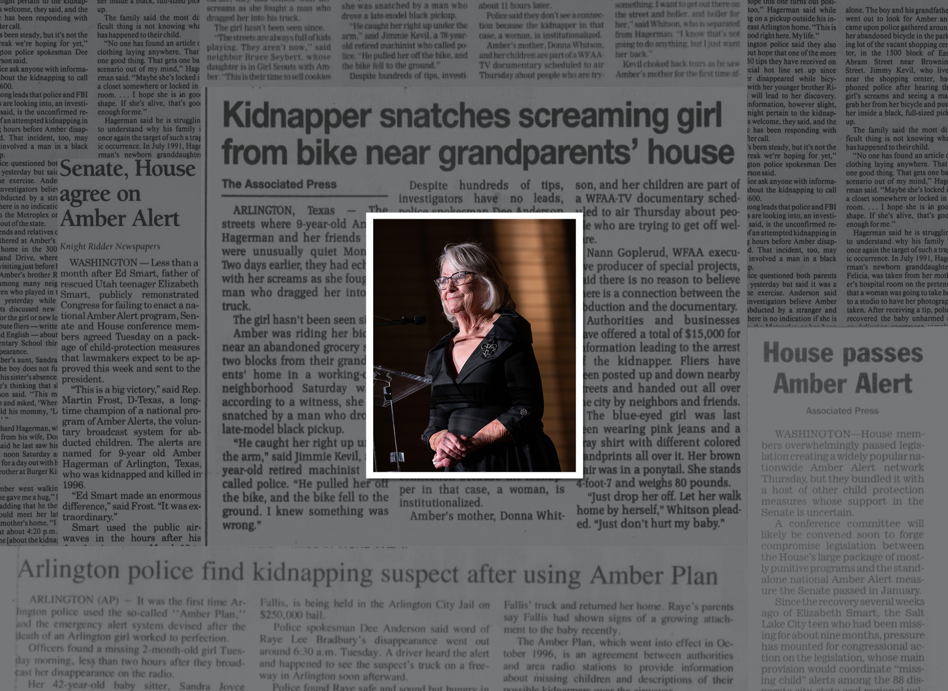 foreground: woman in black dress with gray hair speaks at podium; background newspaper article
