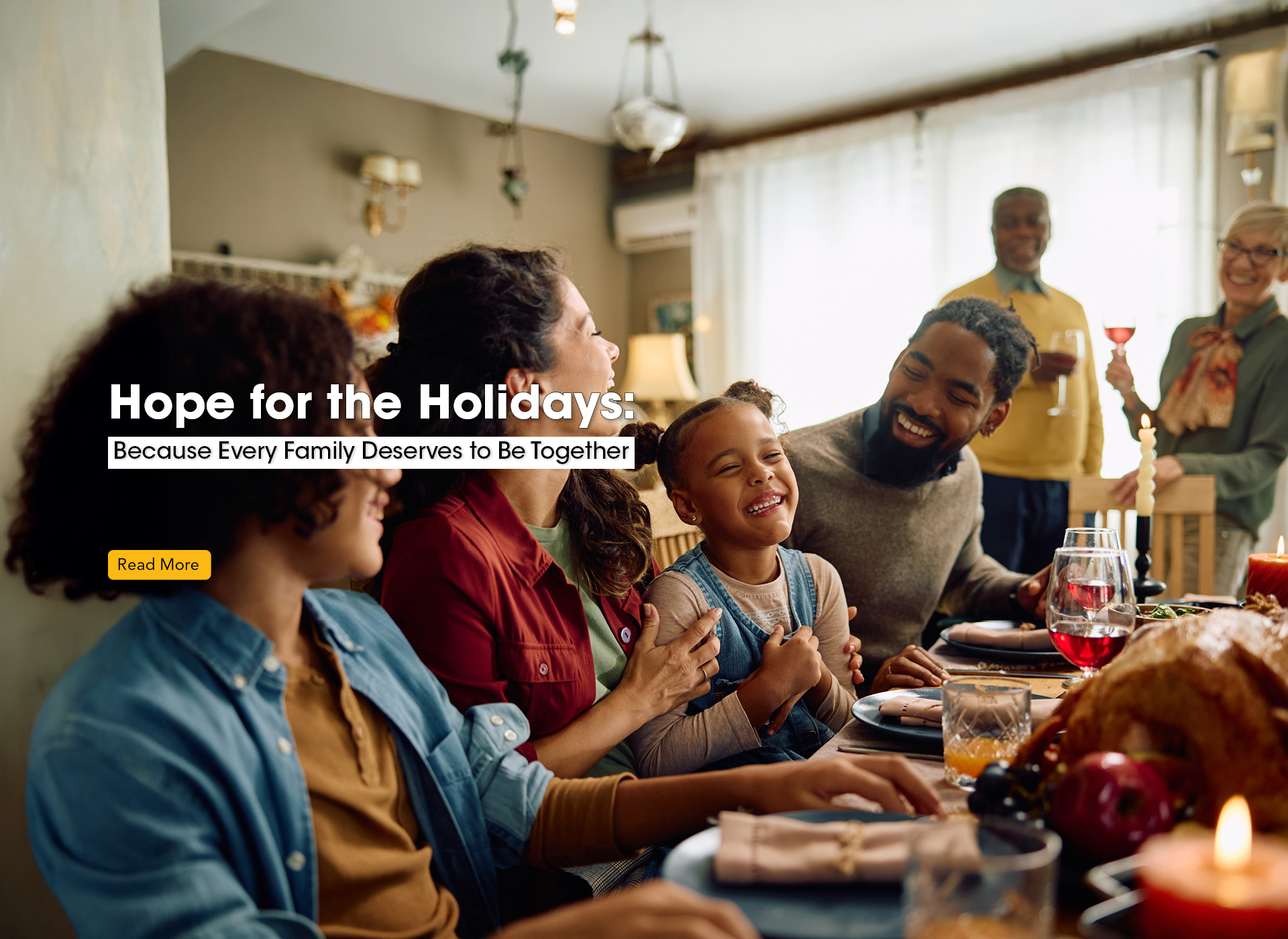 a smiling family sits around a dinner table