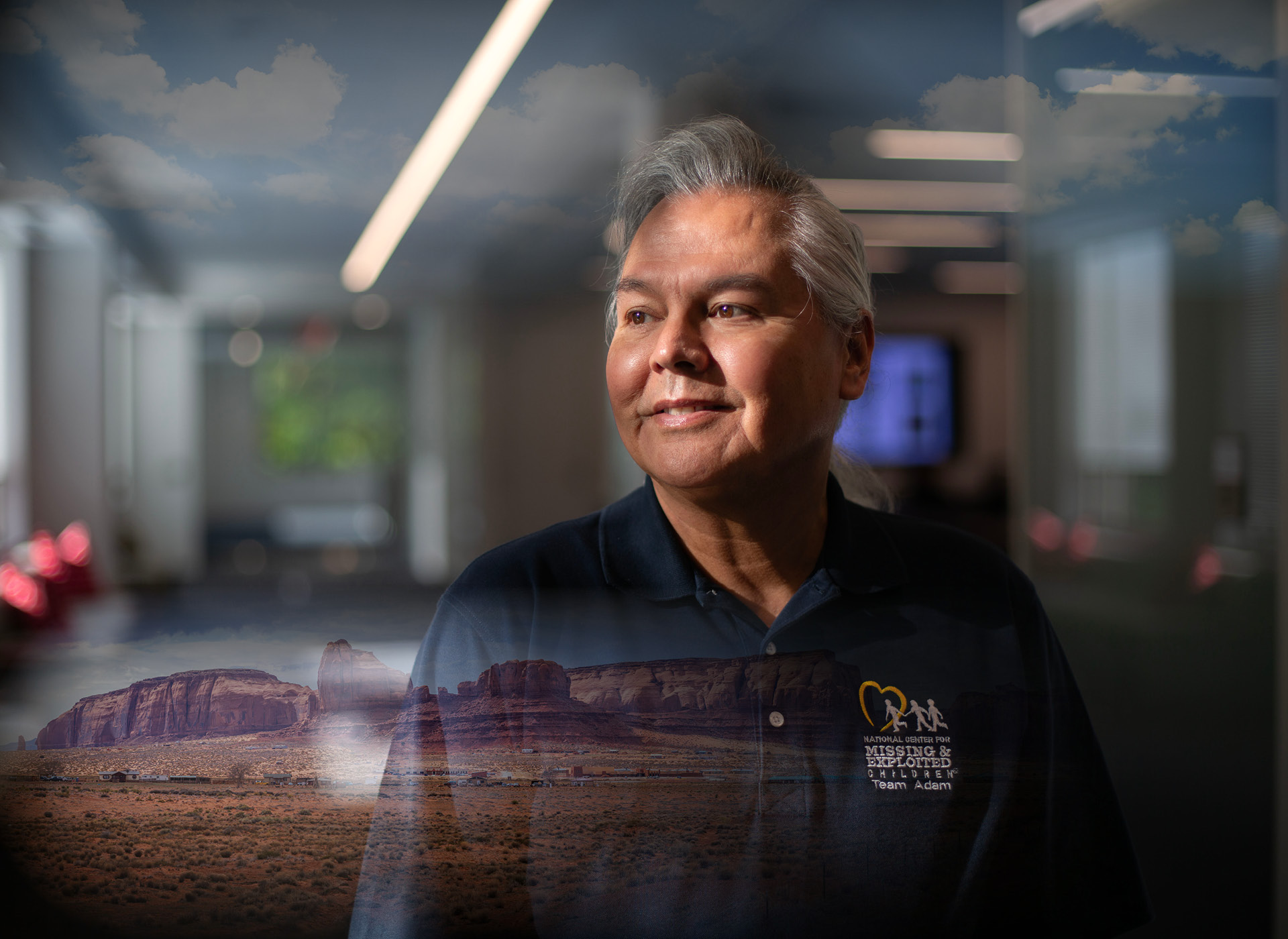 photo of native american man with white hair; background of western mountains